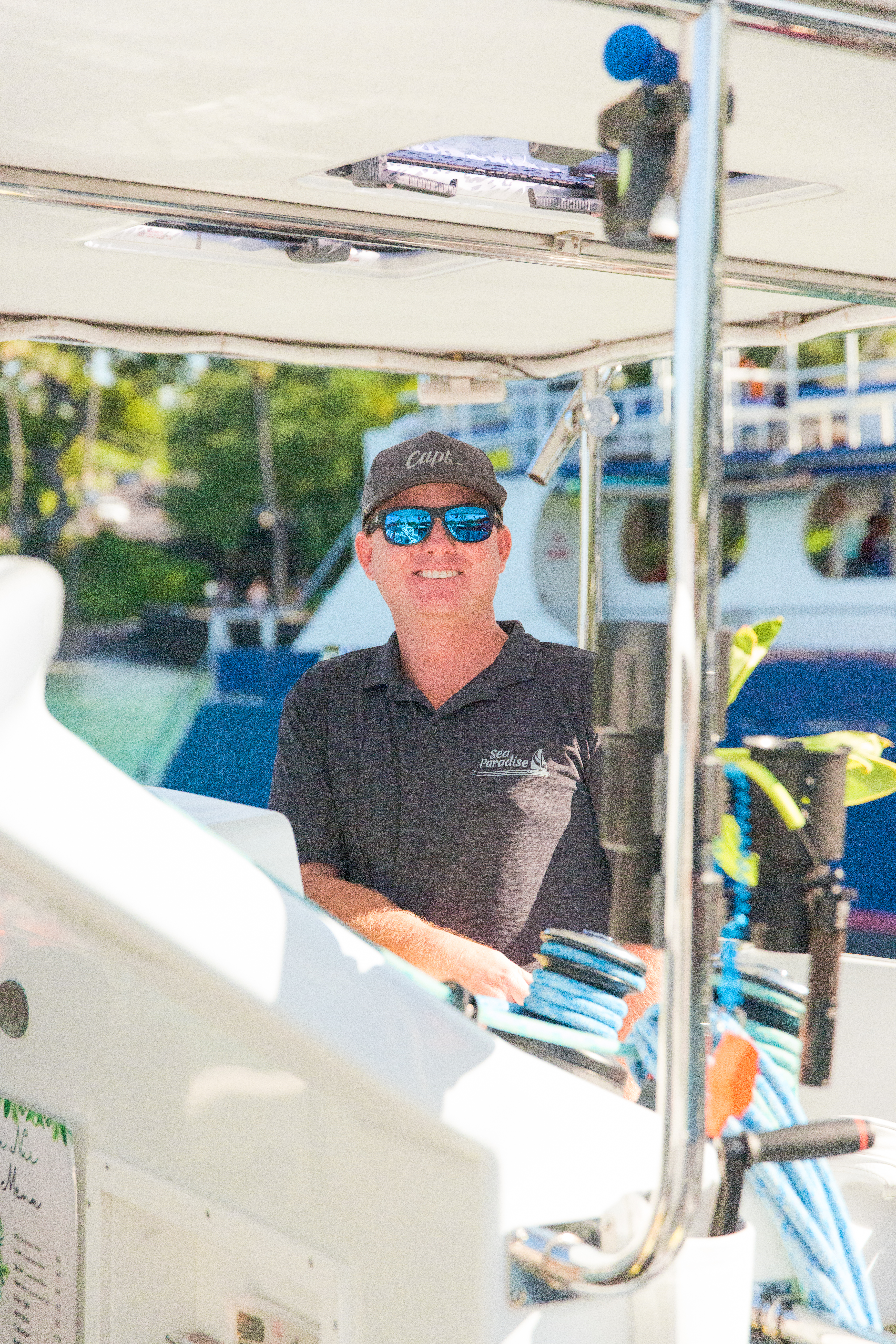 Sea Paradise captain at the Hoku Nui helm, Keauhou Bay — experienced captains on snorkel tours Kona, manta ray tours and sailing tours Kona, seaparadise.com