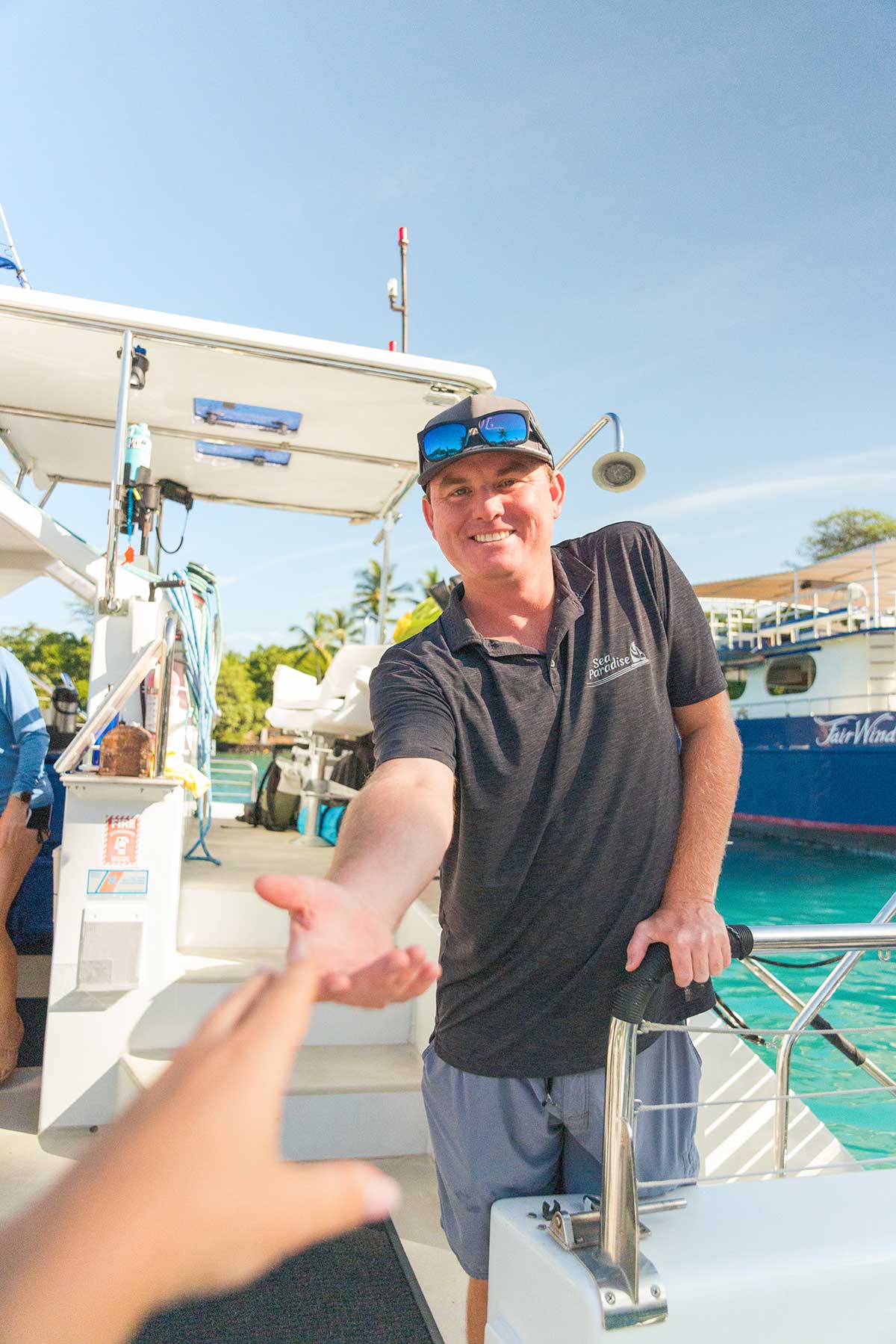 Staff member greeting guest aboard the Hoku Nui